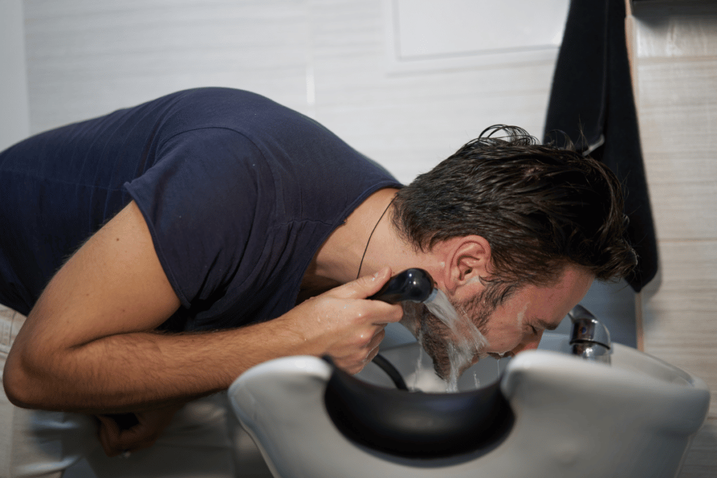 man washing beard to prevent beard acne and scars