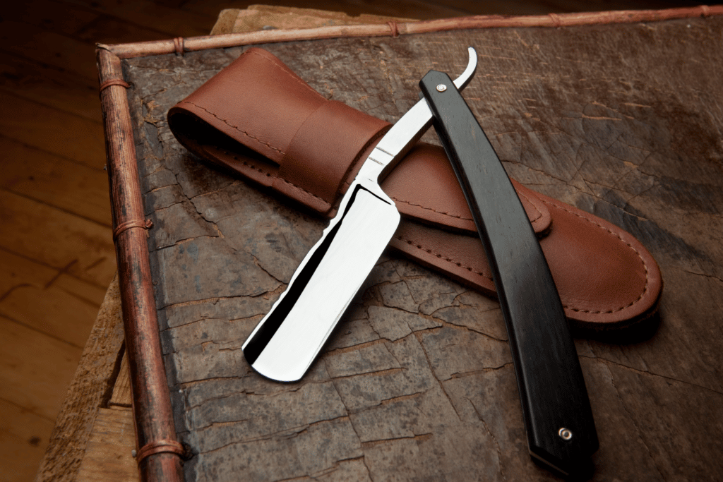 straight razor sitting on a leather pouch
